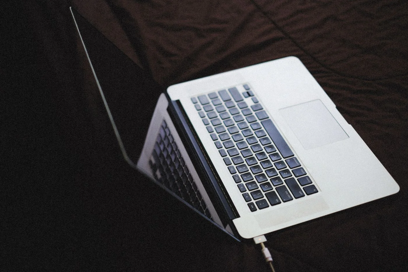 MacBook Pro am Ladekabel mit leuchtender MagSafe-Anzeige