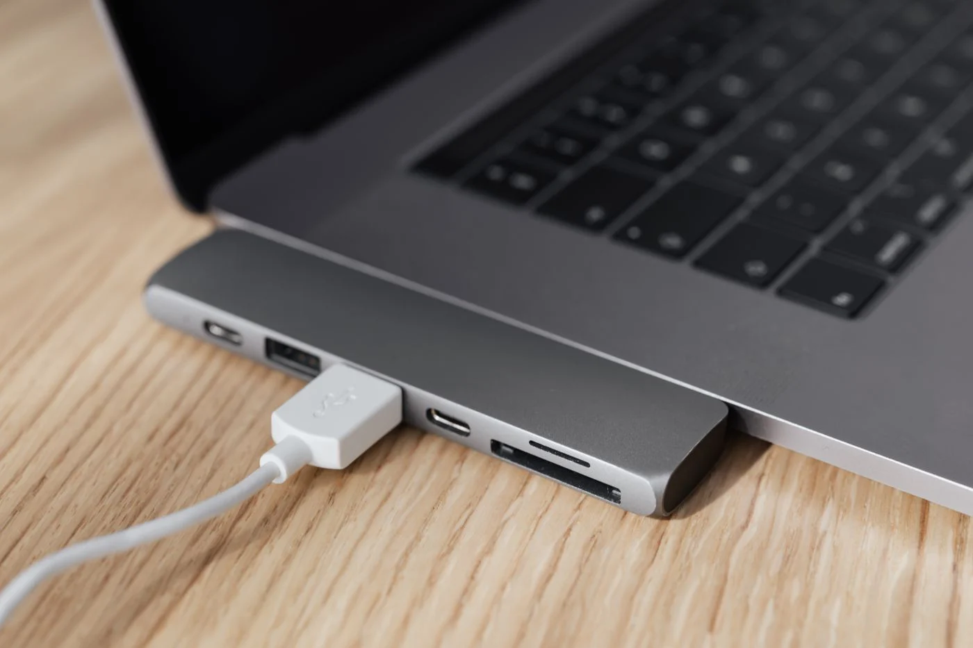 MacBook mit eingestecktem USB-C-Adapter und Kabel